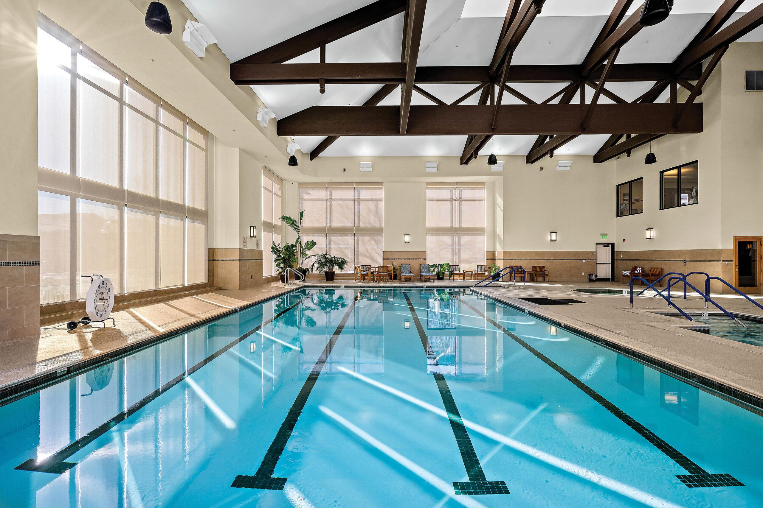 A pool surrounded by windows at University Retirement Community