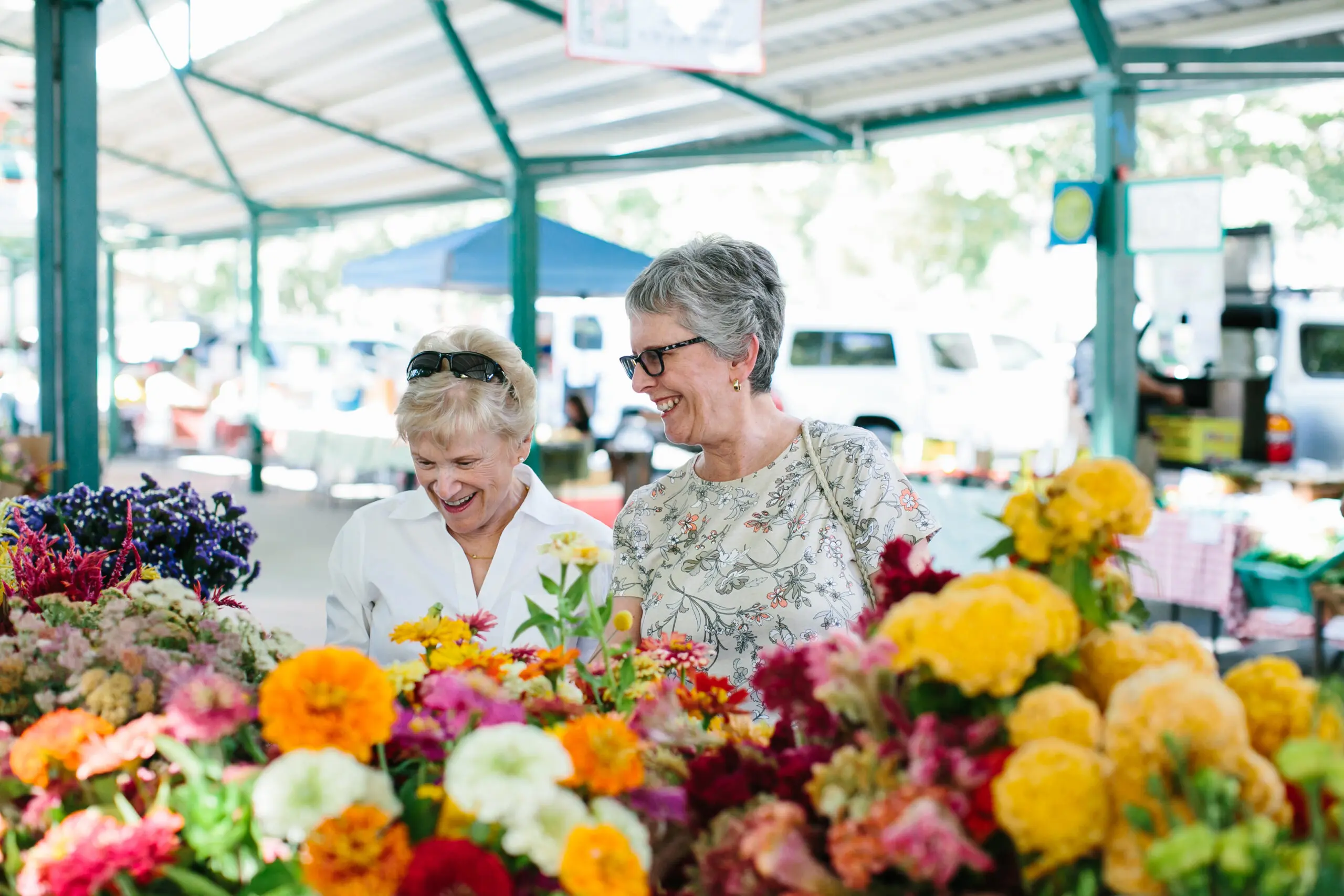 Older woman shop for flowers at a farmers market